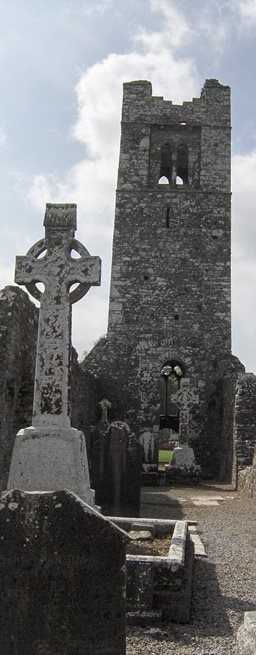 Ruin of Slane Abbey in Ireland with newer celtic cross in foreground.