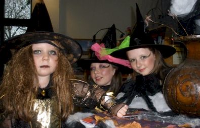 Three young girls dressed as Halloween witches.