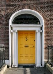 Smart Georgian-style door in Dublin, with fan-light above. Door painted a bright yellow.