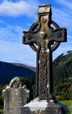 In the hills of County Kerry, a Celtic Cross style headstone beside a smaller marker displaying high-quality carving.